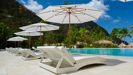 Sugar beach Saint Lucia, is a public white tropical beach with palm trees and luxury beach chairs...