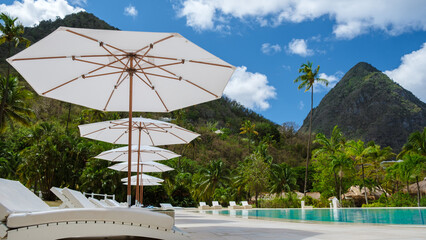 Sugar beach Saint Lucia, is a public white tropical beach with palm trees and luxury beach chairs...