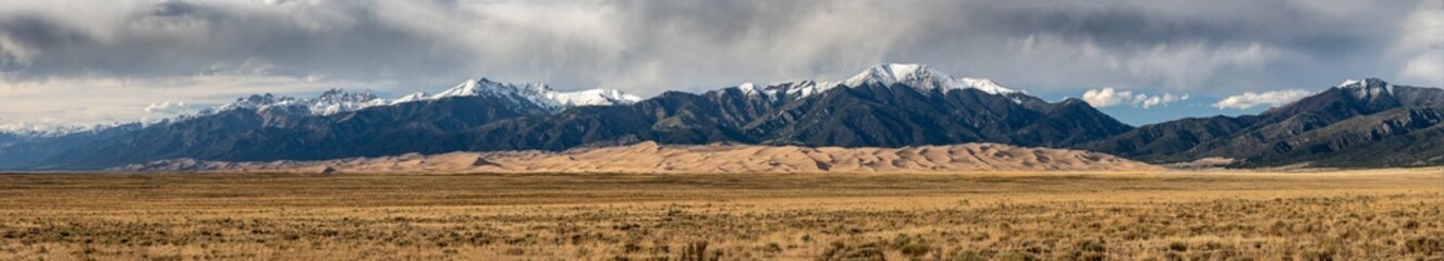 Panorama of Great Sand Dunes Below Snow Capped Mountains