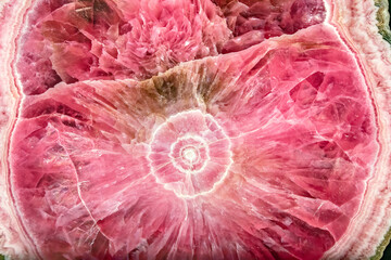Closeup of a large pink quartz crystal with bright lights illuminating it