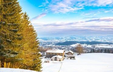 Winter landscape with a snowy farm with trees and houses in Kempten, Bavaria, Germany