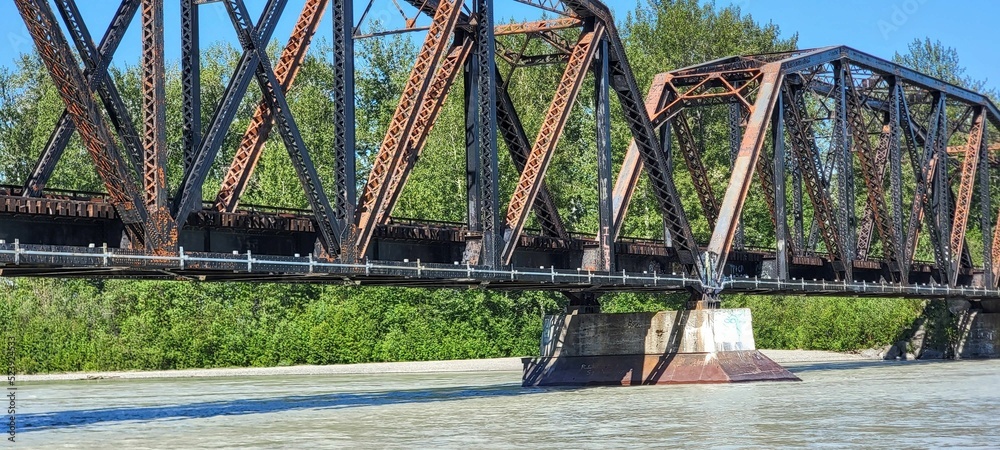 Sticker Panoramic shot of an old metal bridge in Alaska