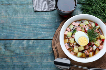 Delicious cold okroshka with kvass served on blue wooden table, flat lay and space for text. Traditional Russian summer soup - obrazy, fototapety, plakaty