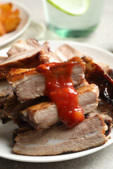 Delicious grilled ribs with sauce on table, closeup