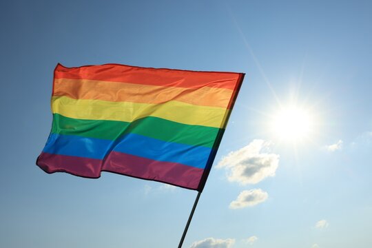 Bright LGBT flag fluttering against blue sky. Lesbian concept