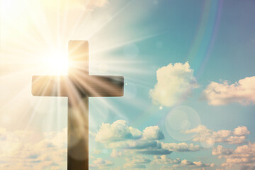 Silhouette of cross against blue sky on sunny day. Christian religion
