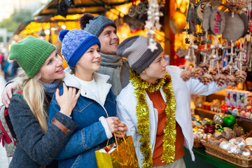 Portrait of smiling family with teenager girl and boy choosing decorations at Christmas fair