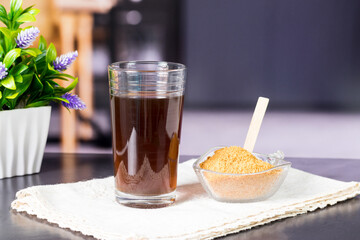 granulated panela and agua de panela or sugar cane sweets and lemon in the kitchen, typical food of Colombia