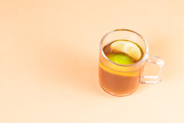 agua de panela or sugar cane candy and lemon on a orange background with copy space, typical food from Colombia
