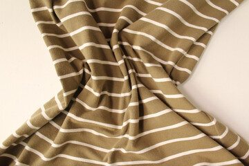 Green ocher crumpled fabric linen with white stripe for creative background. Copy space. Natural...