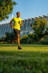 Hispanic man jogging in the garden of the city of arts and sciences park, Valencia, Spain.