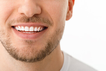 Obraz premium A man is smiling. a smile with white teeth. Close up image. White background with copyspace.