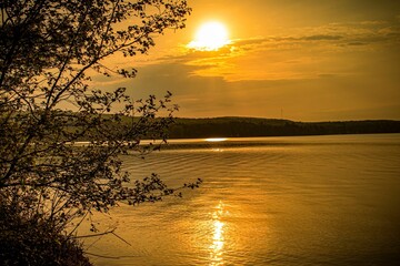 Beautiful waterscape surrounded by trees and a scenic sunset skyscape