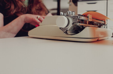 vintage typewriter on desk with older woman typing