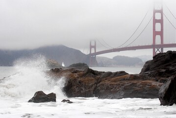 Baker beach in the fall with tide coming in and golden gate bridge