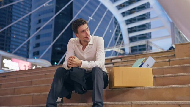 Caucasian businessman sitting outdoor after unemployment from company.