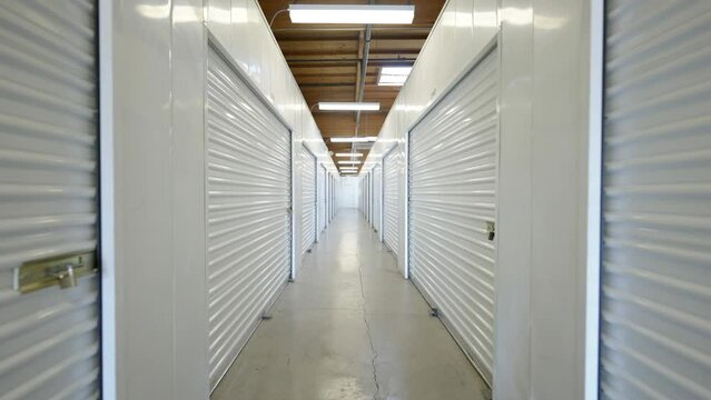 Interior shot down corridor with self storage units at storage facility using locked rolling garage doors.