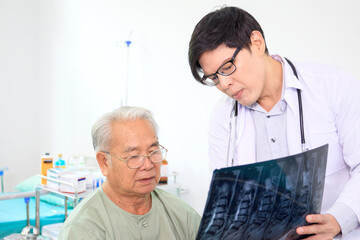 Obraz premium Asian elder adult having a consult with doctor about his disease, doctor explains the x-ray film to Asian senior adult. Health care and wellness in aging society.