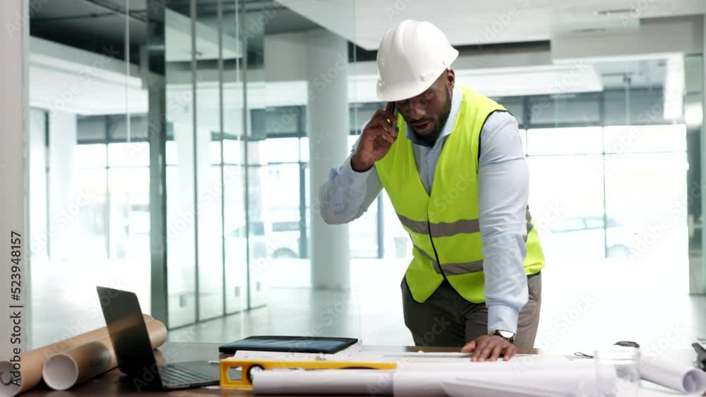 Poster A male engineer talking on the phone, happy and smiling in an office, at a desk with blueprints and equipment. A successful African architect on a call confirming designs for a construction project.
