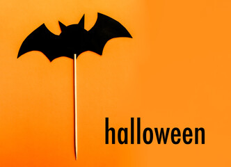 halloween poster, black silhouette of a bat isolated over bright orange background, holiday banner