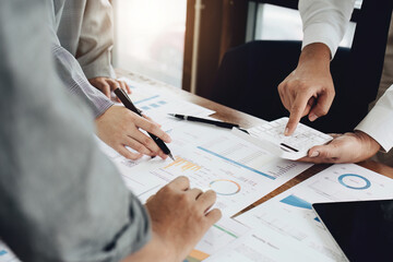 businesspeople using calculator to calculate with partners adjusting marketing strategies