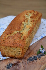 Budin de vainilla y semillas de Amapola , budin, vainilla, semillas, gris ,  amapola , masa dulce , suave, pasteleria, preparacion, sobre mantel floreado, flores, pequeñas, celestes, alimento, 