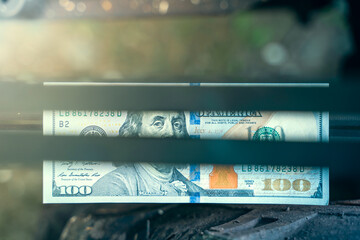 One hundred dollars in the gap between the motoblock pulley belts. Benjamin Franklin on the...