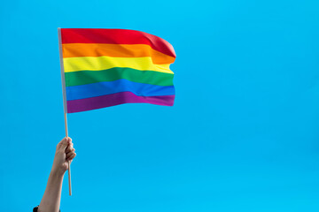 Rainbow flag waving on blue background
