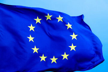 European Union Flag waving on blue background