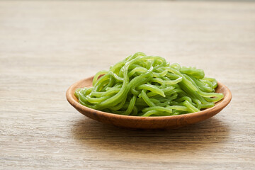 green konjac noodle in wooden plate on wood table background                  