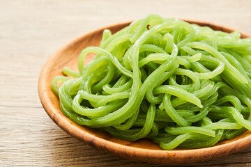 green konjac noodle in wooden plate on wood table background                  