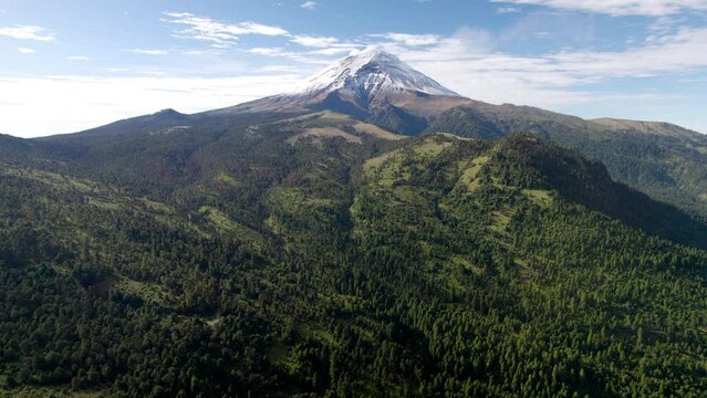 backwards drone in descent short showing the snowy top of popocatepetl volcano in mexico city