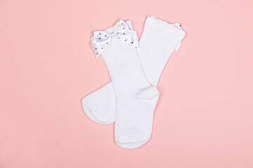 high white children's socks for girls with big bows for party wear on a pink background