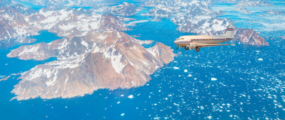 Vintage type old metallic propeller airplane in the sky - View from airplane of melting polar ice cap and snowy mountains - Greenland