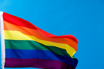 Fototapeta premium Rainbow flag waving on blue background