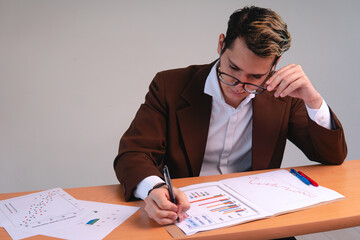 Business man reviewing important charts. Business executive working at his desk analyzing data....