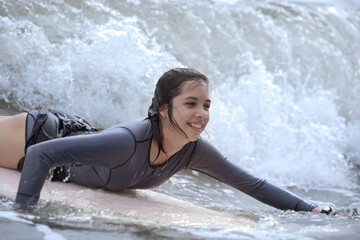 Happy pretty surfer teen girl on the board enjoy with water sport at vacation holidays
