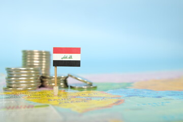 Selective focus of Iraqi flag in blurry world map with coins. Iraq economy and wealth concept. - obrazy, fototapety, plakaty