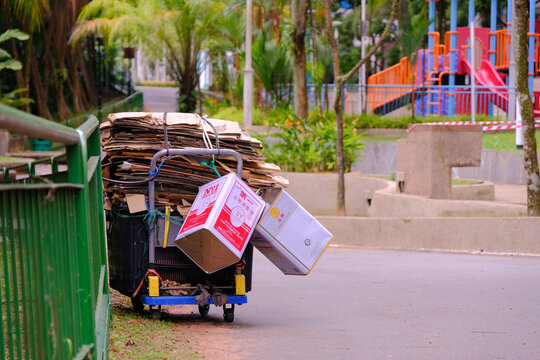 Singapore feb2021 A trolley of a collection of flattened corrugated cardboard boxes is locked to the railings in a public park, to prevent theft