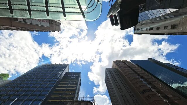 Look up view of sun and cloud time lapse between Mong Kok skyscrapers, Hong Kong