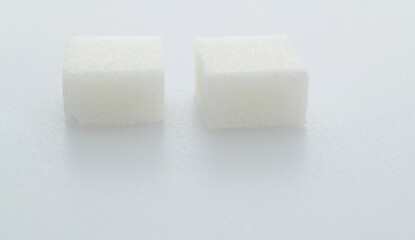 Two sugar cubes on white background