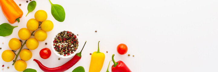 Yellow and red tomatoes, hot peppers,spinach and spices on a white background, food banner, top view, copy space