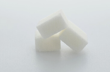 Three sugar cubes on white background
