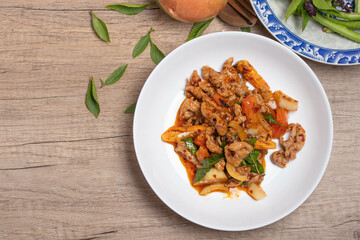 Pork stir fried in chili paste with tomatoes and onions in a white dish