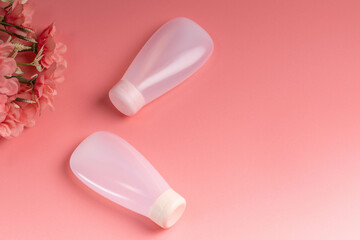 White cosmetic product in tubes on color background. Mock up skincare cosmetic package on pink.