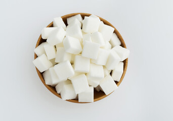 Sugar cubes in a bowl on white background