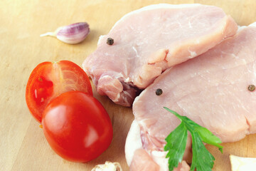 Fresh raw meat with herbs, spices on rustic background.