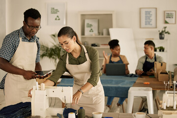 Learning, clothes making and creative workshop with a sewing teacher teaching clothing design. Fashion class and adult students in a design studio working, talking and discussing style ideas indoors