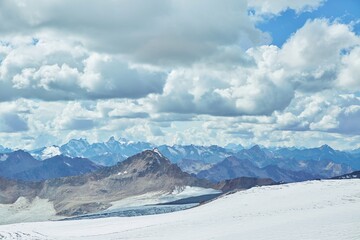 Winter mountain landscape. High mountains covered with white snow. Over the mountains bright blue sky