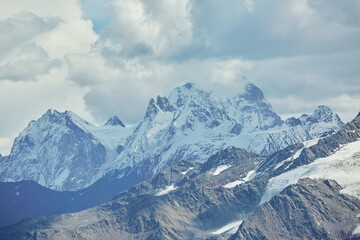 Fototapeta na wymiar Mountain landscape of the Caucasian ridge with snow lying on them.